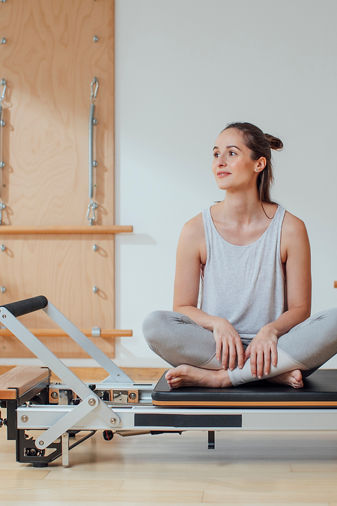 Woman sitting on a reformer after Clinical Pilates at Eastside Physio + Co