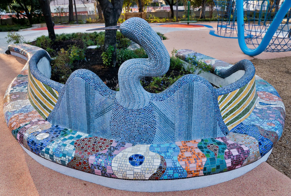 Mosaic tiled bench with back in the shape of an anhinga bird in a children's park in San Antonio Texas.