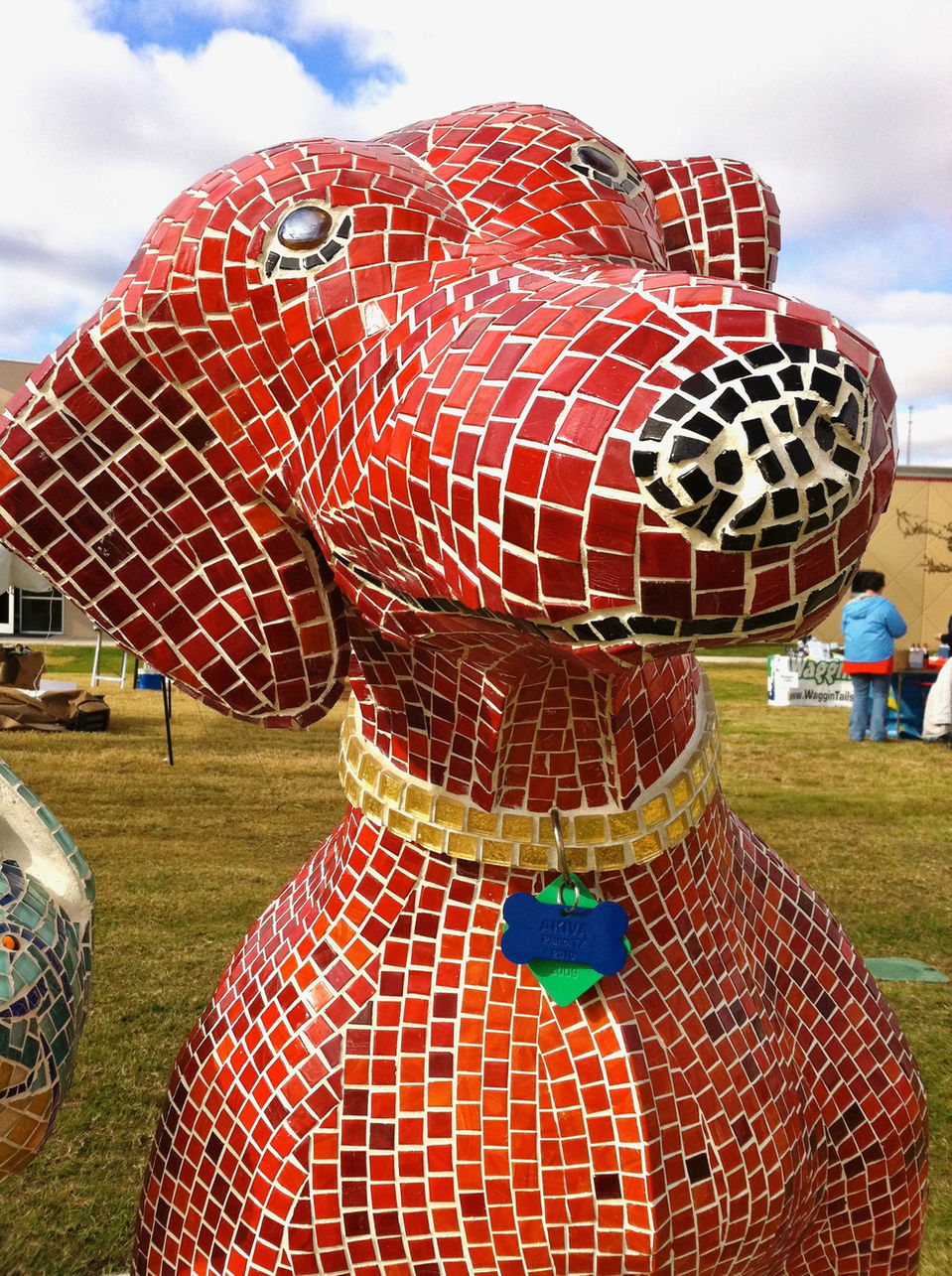 Mosaic tile sculpture of a dog in shades of red.