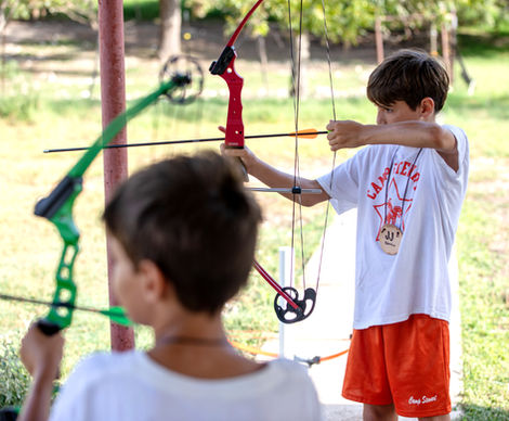 Two boys releasing bows from arrows.
