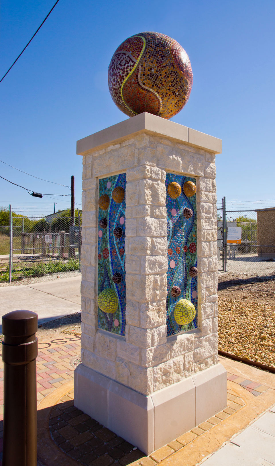 One of two mosaic tiled pillars with a globe structure on top at the entrance to Walters Street in San Antonio.