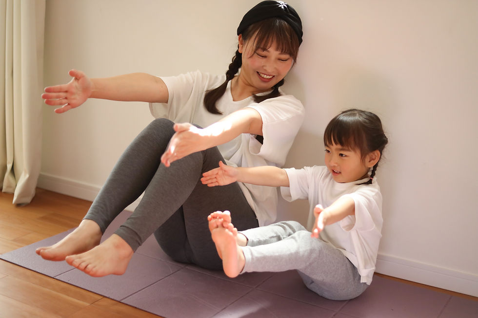 ヨガマットの上で一緒にストレッチをする親子