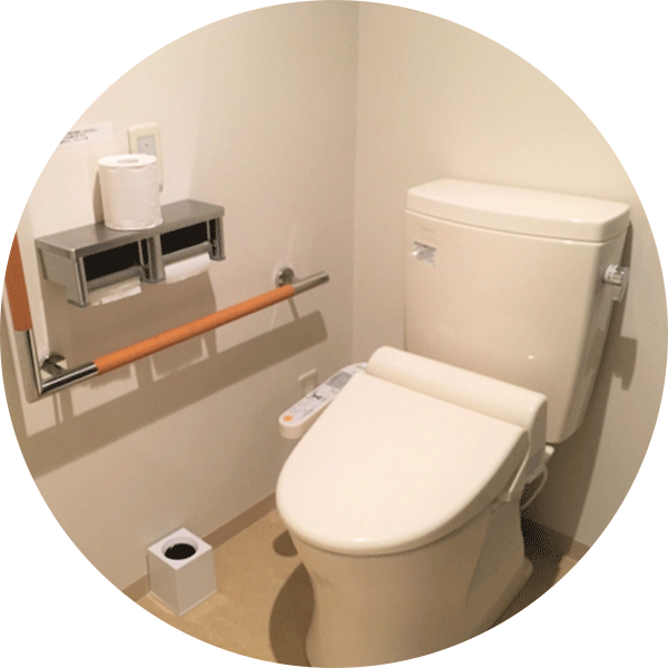 トイレの画像、トイレットペーパー、手すり、ビデ付きトイレ。清潔感のある空間。