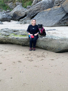 A woman on the beach with her dog.