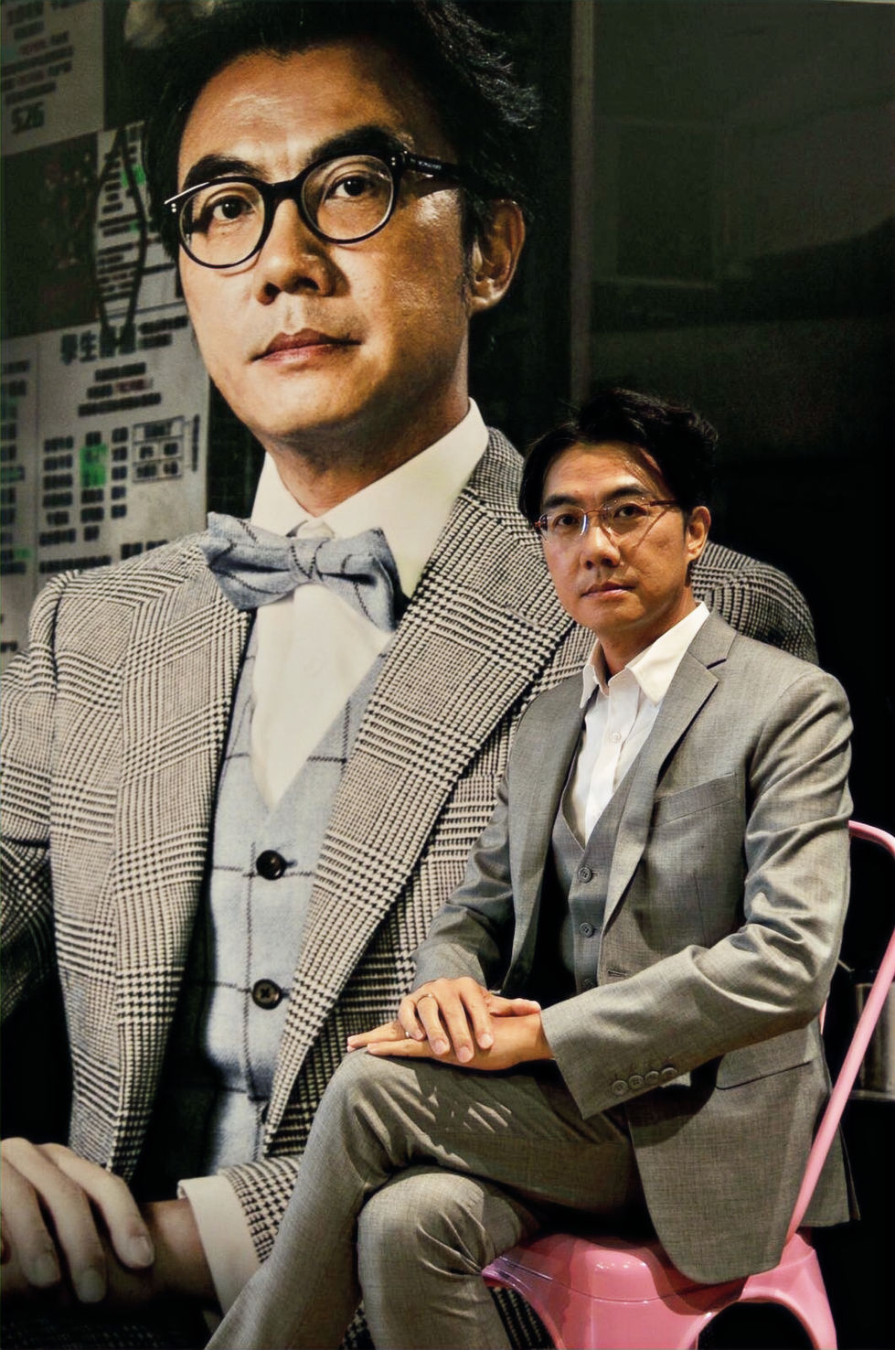 Ben Sir 穿著灰色格紋三件式西裝,於大型宣傳海報前留影,展現才子風範。