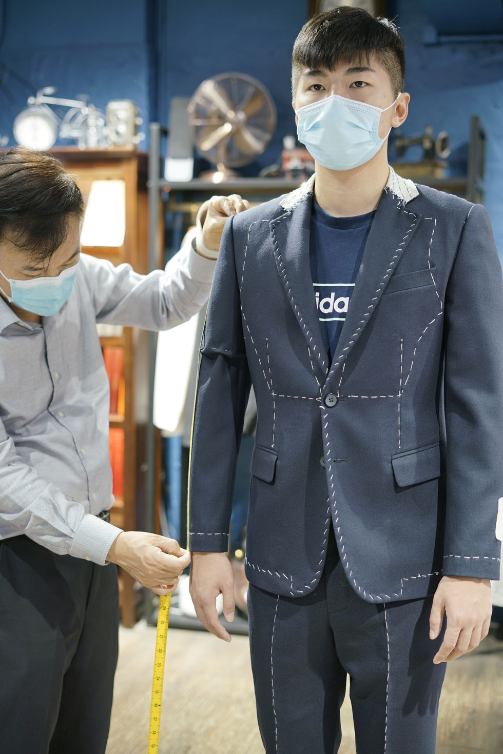 游學修進行西裝mock-up試身過程,裁縫師細心調整袖長比例。
