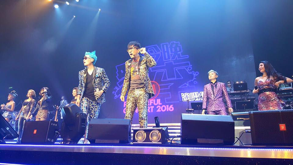 主音結他手與貝斯手在演唱會舞台中央並肩表演,服裝風格張揚搶眼