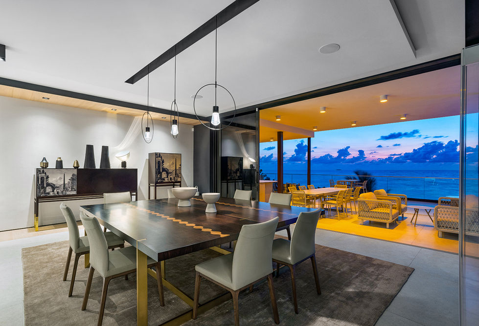 Contemporary dining and living interior with panoramic water view at Highland Beach