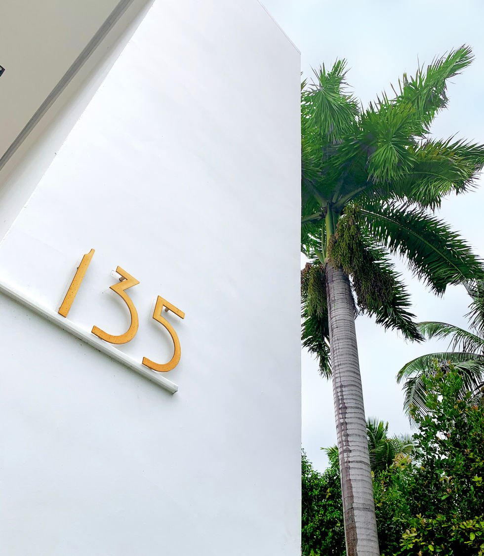 Brass house number and tropical landscaping at entrance, Palm Island residence, Miami Beach