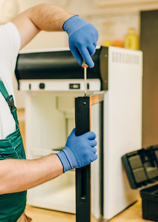 worker-with-screwdriver-repairs-refriger