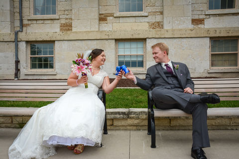 bride and groom in wedding attire, toasting each other with blue flutes