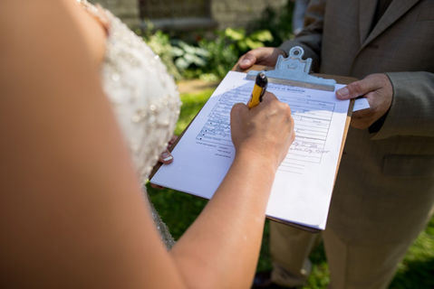 Image of bride signing paperwork in wedding dress