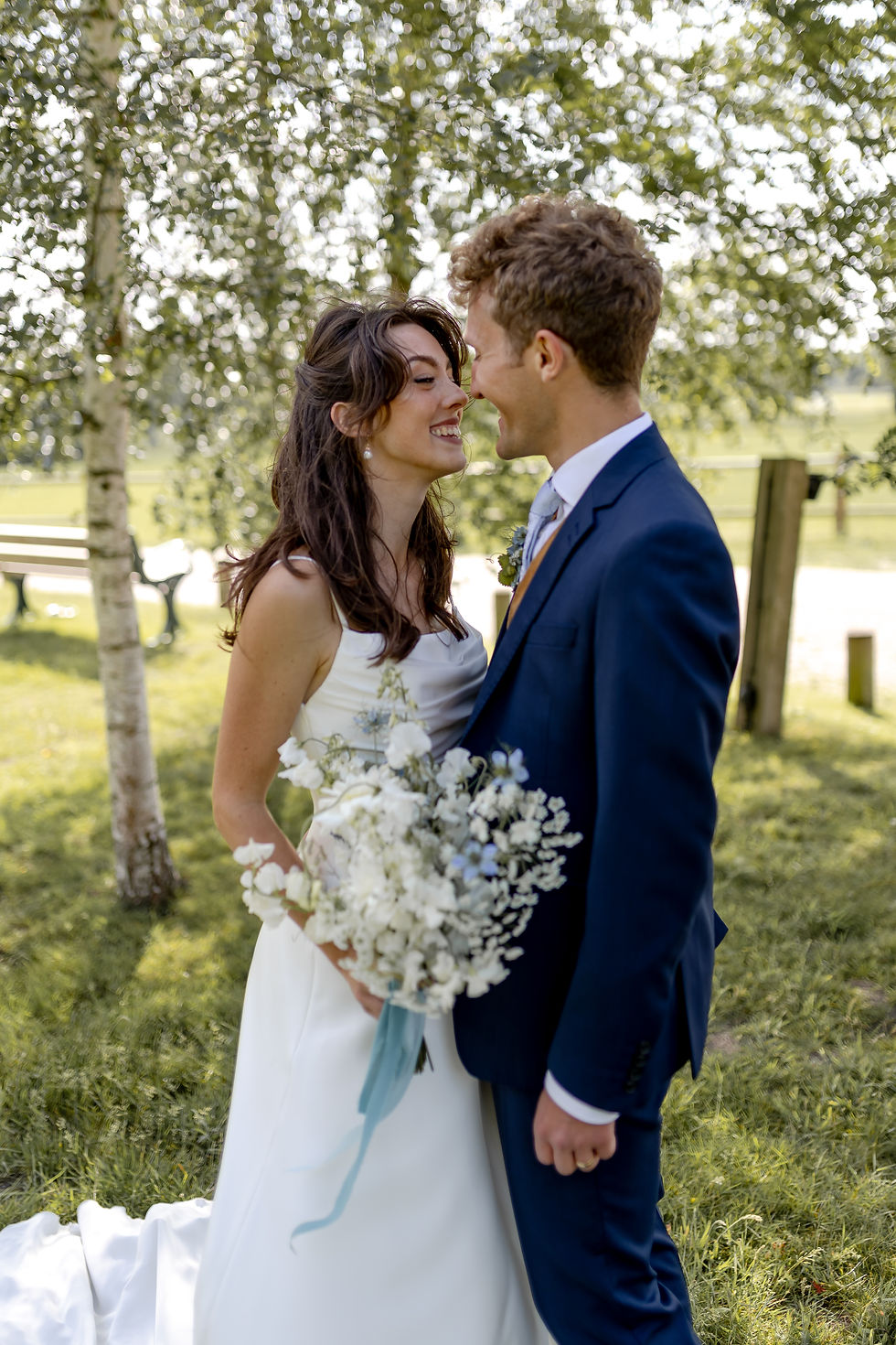  Smiling bride and groom at a June Surrey wedding near Reigate, featuring bridal flowers and bouquet by Feature Florals.