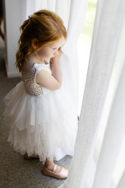 Flower girls peeking out the window at the tree church wedding venue