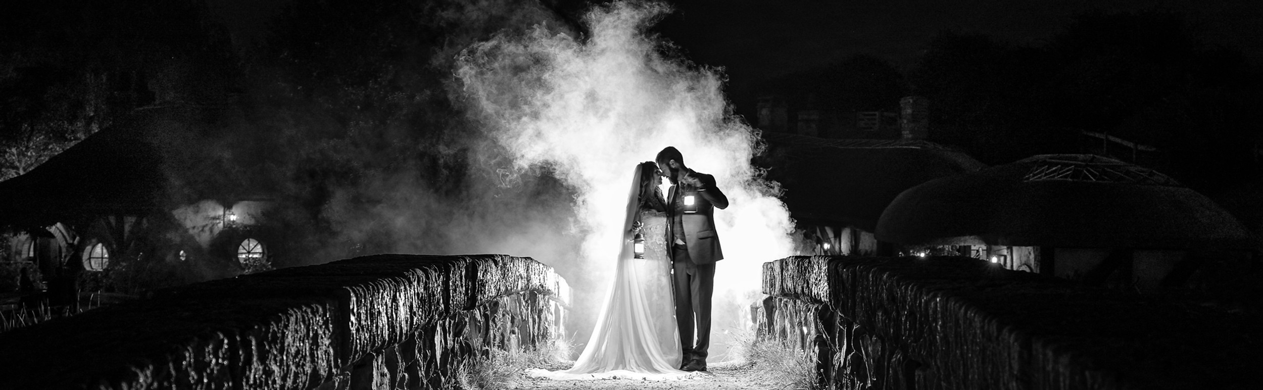 Couple on bridge at Hobbiton wedding with smoke, Waikato wedding photography.