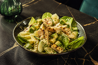 Fresh salad bowl with grilled chicken, avocado, mixed leaves and herb dressing
