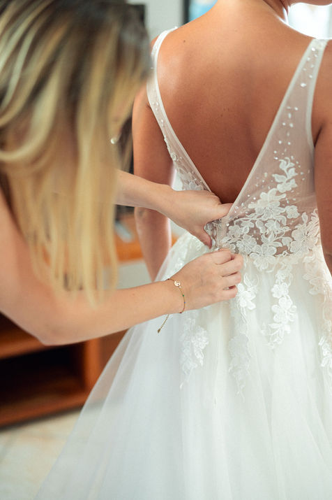 Préparatifs de la mariée avec fermeture de la robe vue de dos