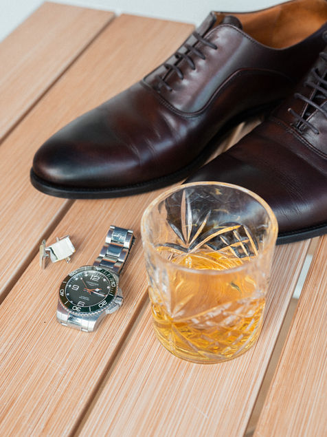 Détails du marié avec chaussures, montre et verre de whisky pendant les préparatifs du mariage.