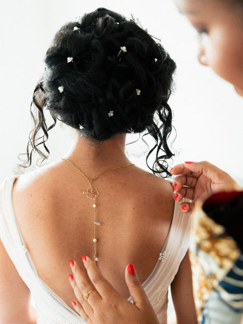 Détail du dos de la robe de mariée et du bijou pendant les préparatifs