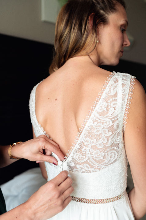 Préparatifs de la robe de mariée avec détail de la dentelle dans la chambre d’hôtel