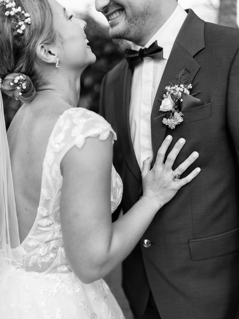 Gros plan romantique des mariés pendant leur séance couple en noir et blanc.