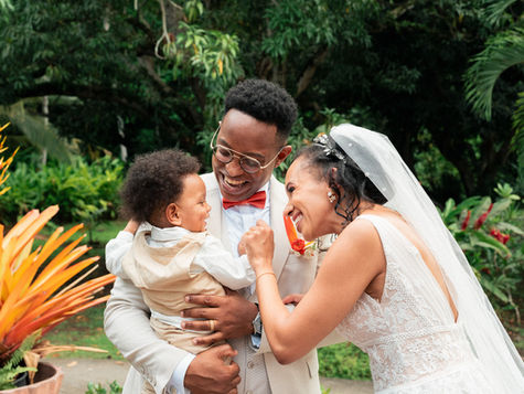 Les mariés jouant avec leur enfant pendant la réception du mariage