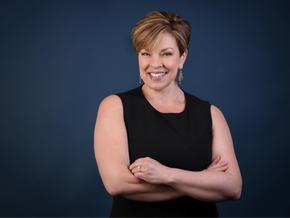 Professional women’s corporate headshot in Dallas Fort Worth featuring confident businesswoman in black dress against blue studio backdrop, executive branding photography in Bedford Texas.