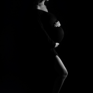 Side lit maternity silhouette photographed in Dallas Fort Worth