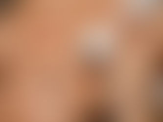 Close-up of a woman receiving a facial treatment as a hand holds a white skincare device to her cheek, calm spa mood
