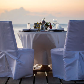 Romantic dinner setting on the beach at sunset.