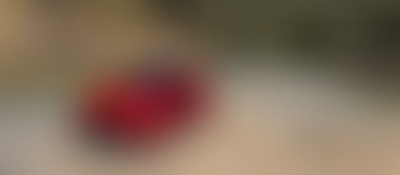 A red toyota yaris parked near a winding road