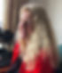 Author photo of Diana Holbourn. Sitting by a window wearing a red jumper