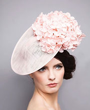 a brunette woman in a flowery side hat looking away from the camera