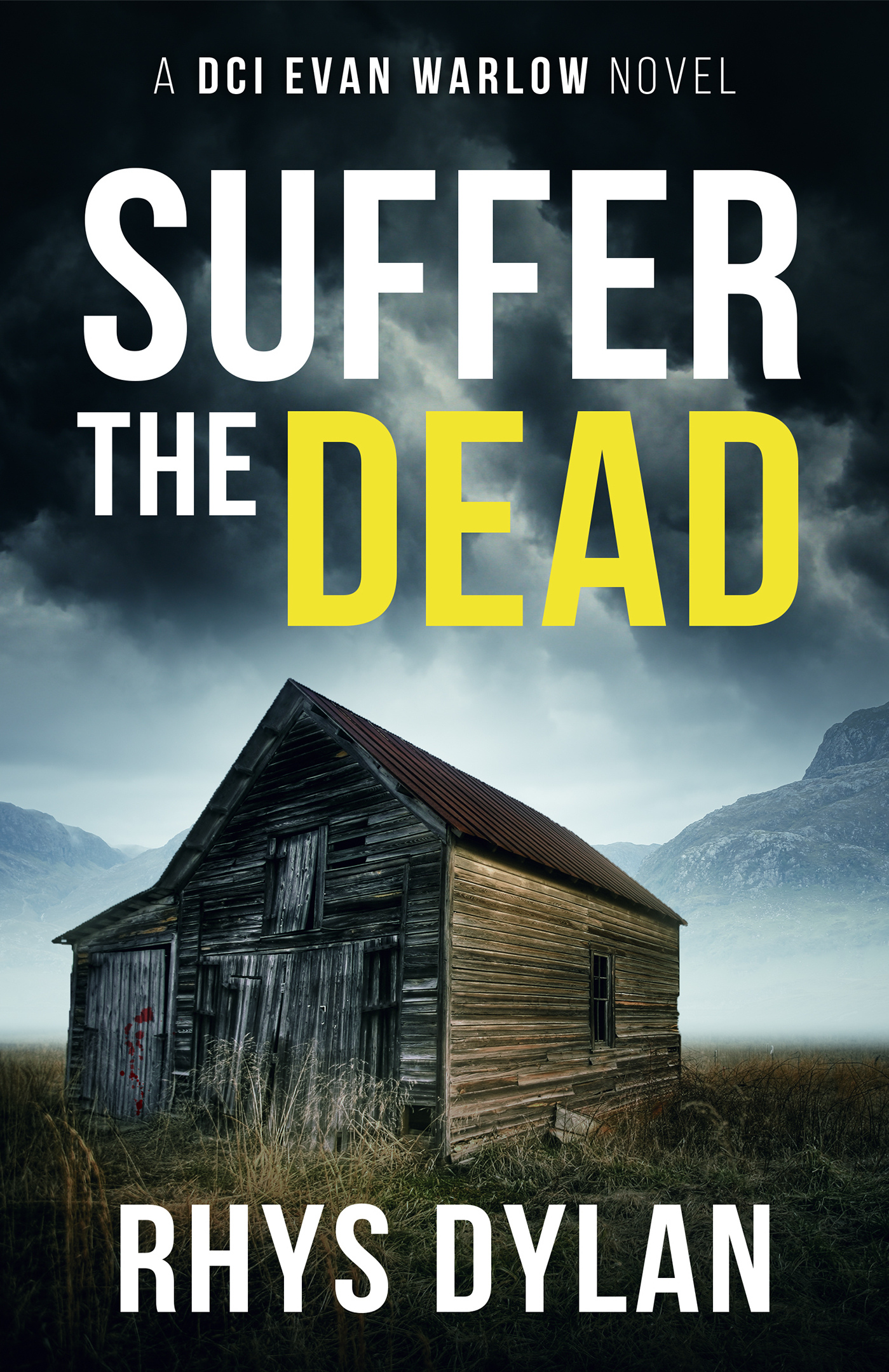 Suffer the Dead by Rhys Dylan, DCI Evan Warlow Book 4. Weathered barn in a desolate field with misty mountains overhead.