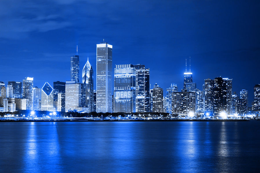Blue city skyline at night with DEAS building reflected in water