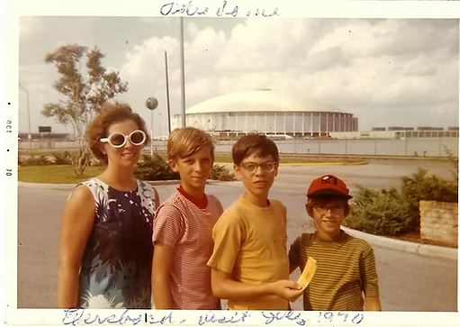 An old family photo of Jeff with his family in front of Houston Astrodome gray sky 