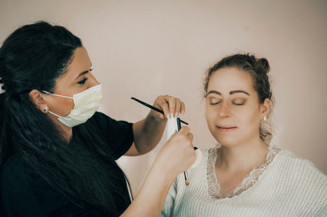 Visagistin mit Maske beim Augen-Make-up einer entspannten Braut – mobiles Brautstyling mit Hygienekonzept in Illingen, Enzkreis