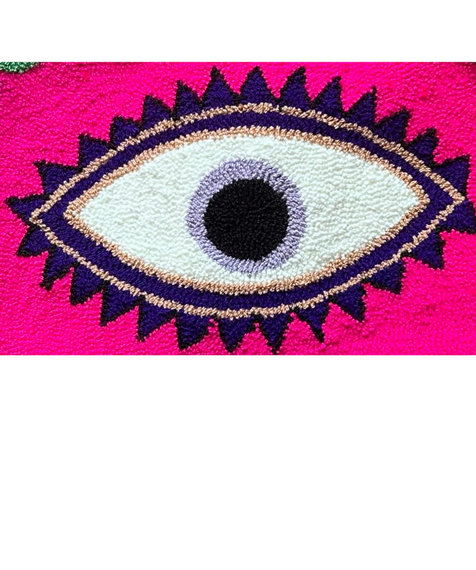 Detalle bolsa wayuu con diseño ojo en fucsia