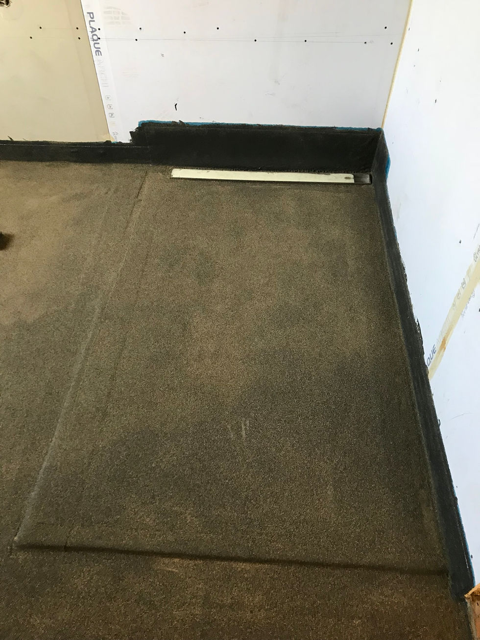 Revêtement de sol en résine sous parquet et carrelage dans une salle de bain pour une étanchéité optimale.