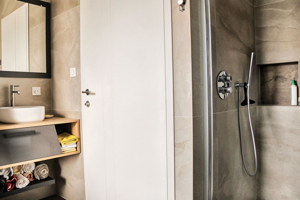 Salle de bain chaleureuse alliant bois et carrelage, créant une atmoshère élégante et moderne.