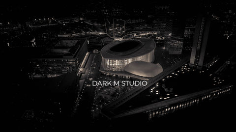 Photographie aérienne nocturne en noir et blanc de la Philharmonie Luxembourg, mettant en relief le rythme des colonnes éclairées et les jeux de clair-obscur sur la structure architecturale.