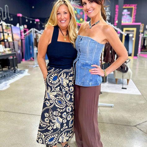 Here is an image of Michelle Randazzo and Alaigna Chagnon, two style icons in Boston who came together today to talk all things fashion. Michelle, with her long blonde flowing hair, wore a super cute summer sundress with black top and batik print skirt and Alaina wore brown pants with a denim corseted bustier top. Both were all smiles