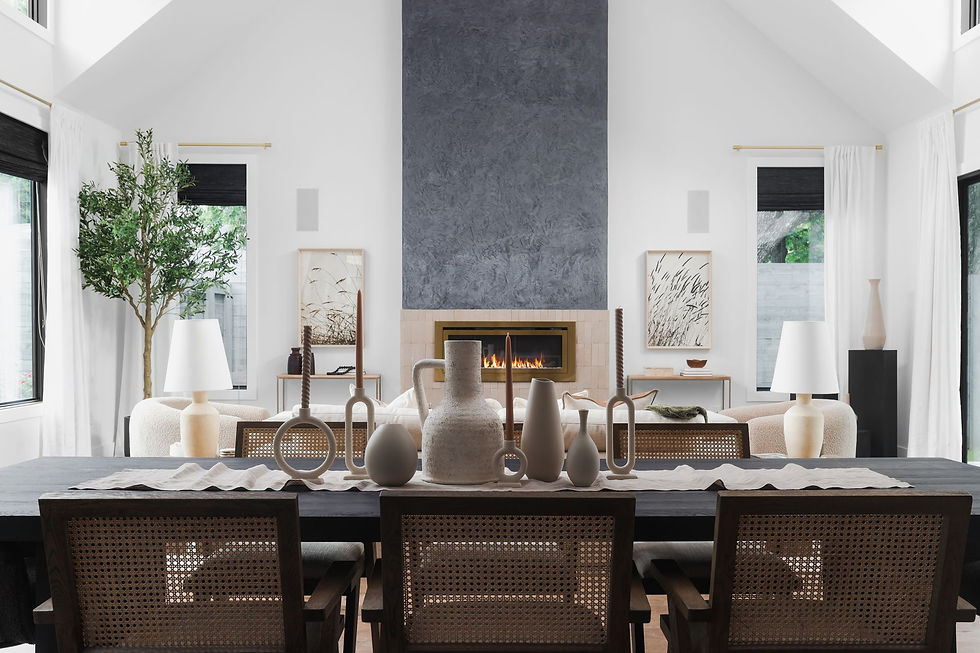 Staged dining room with woven chairs, ceramic vases and stone fireplace in an Austin home