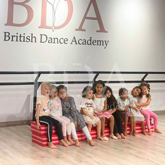 Kids posing and singing at the beginning of their dance performance at summer camp at British Dance Academy in Dubai.