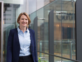 Karin in front of a glass office space