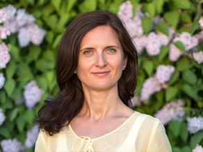Carmen in front of a green background with flowers