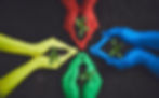 Four pairs of hands, painted in different colors—yellow, red, blue, and green—hold small green plants with soil in their palms, forming a symbolic representation of growth and sustainability against a dark earth background