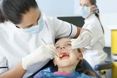 A pediatric dentist in Wake Forest treating a young patient with a chipped tooth.