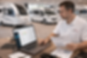 Manager reviewing compliance reports using software in a caravan and motorhome dealership showroom