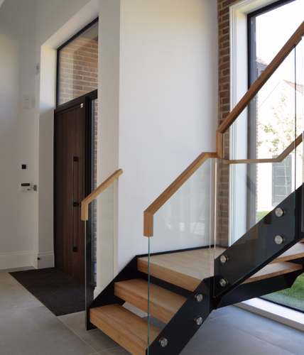 Modern interior with glass and wood staircase.